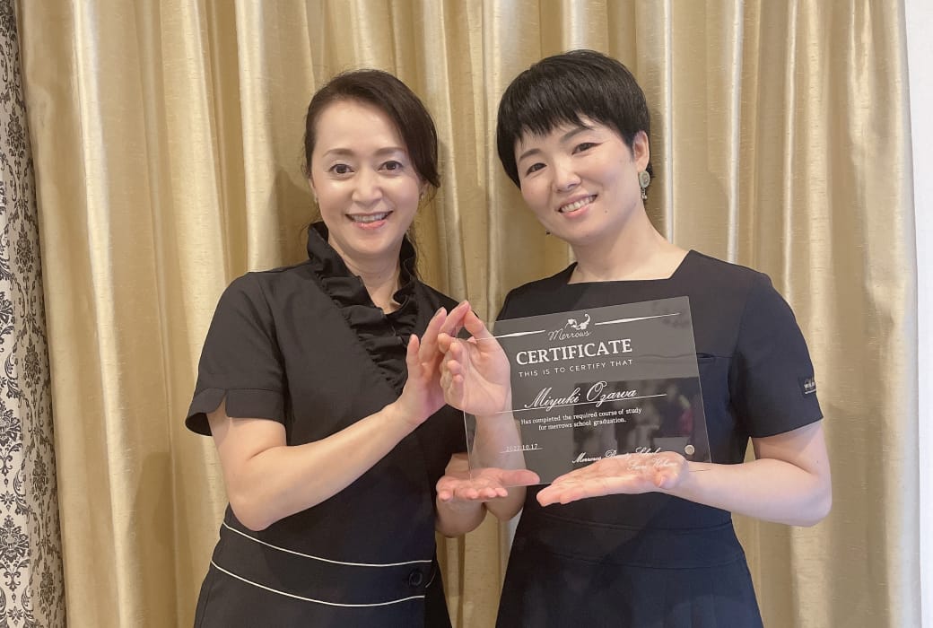 スタッフと資格取得のトロフィーを抱えているシーン