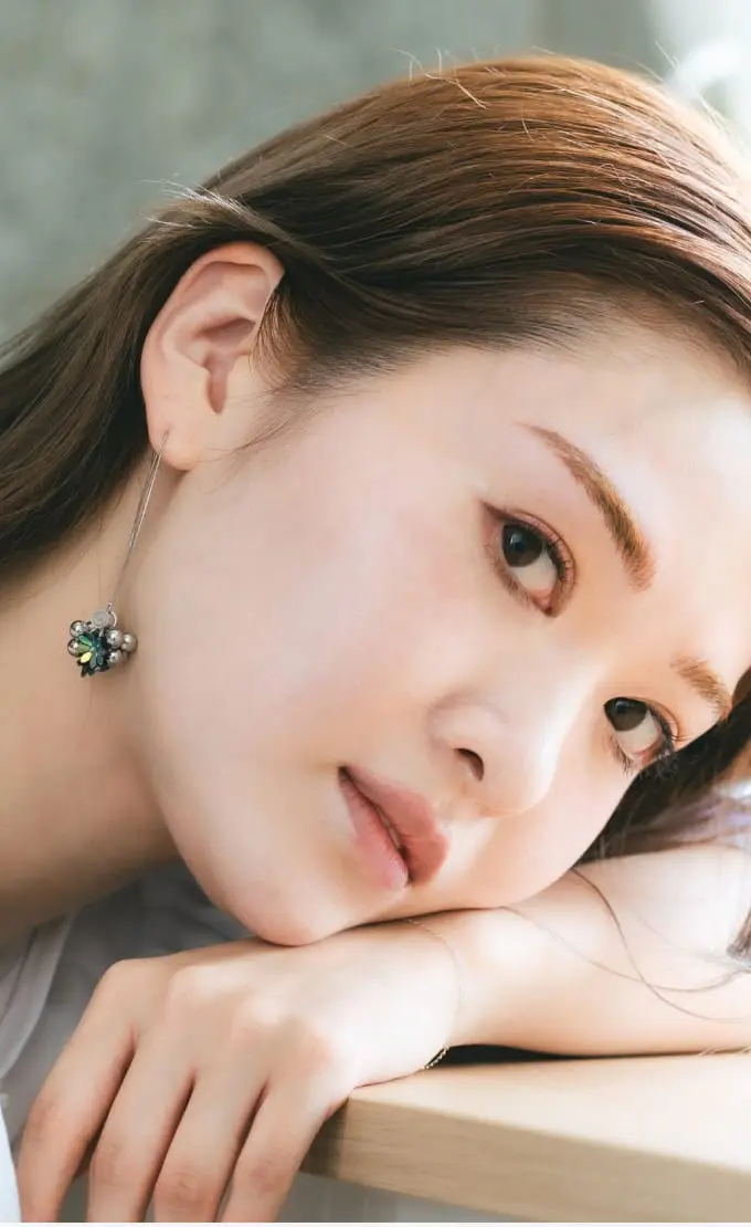 アートメイクをした女性が正面を向いているシーン